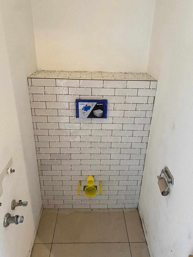 Toiletruimte betegeld met witte metrotegels