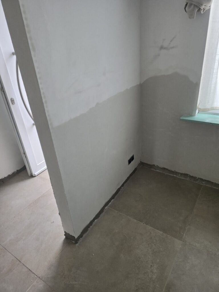 Muur bij het raam met nieuwe sanerende pleister