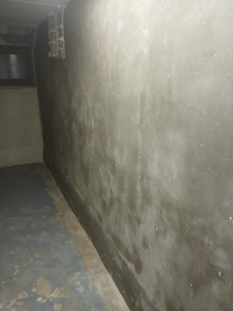 Vochtige kelderwand met vochtvlekken, voor de behandeling